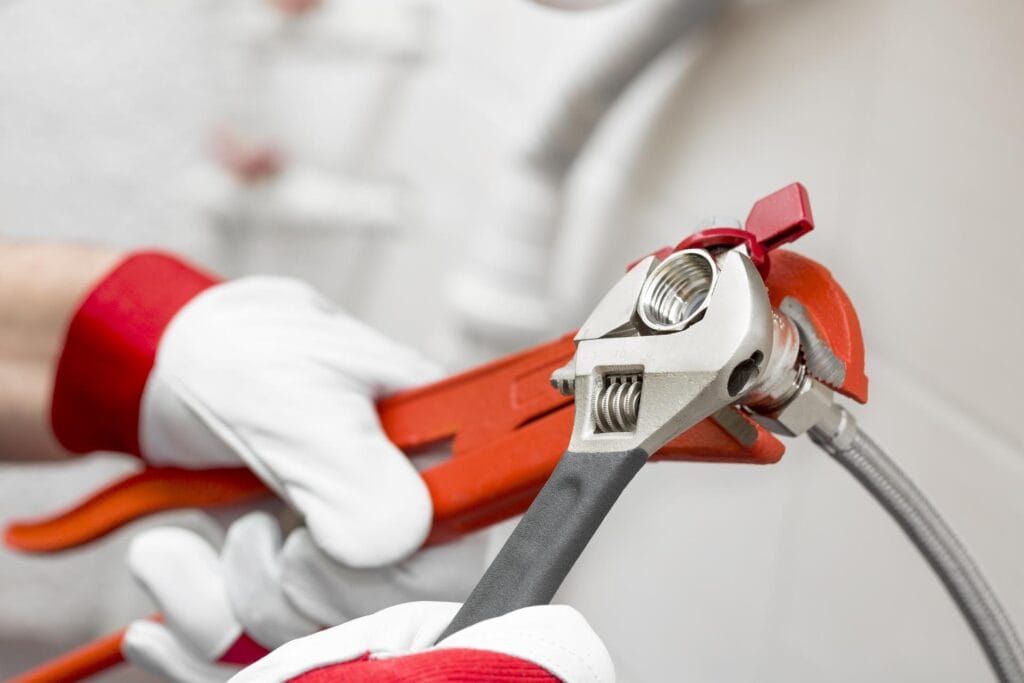Plumber holding pipe wrenches for an emergency repair in Prescott