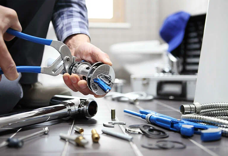 Technician repairing a plumbing fixture with professional tools in Prescott