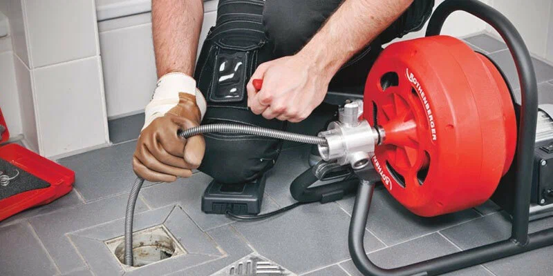Plumber using a drain-cleaning machine in Prescott
