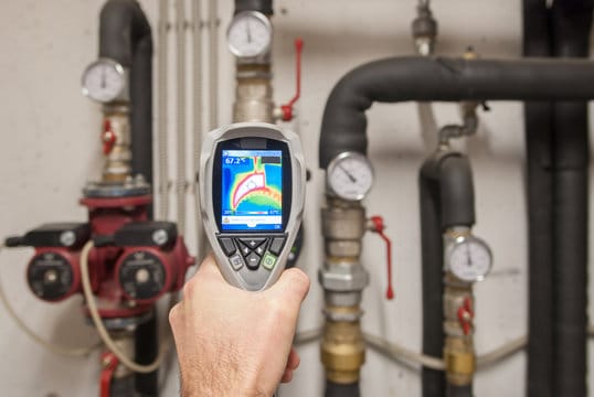 Plumber using a thermal imaging camera to inspect pipes in Prescott