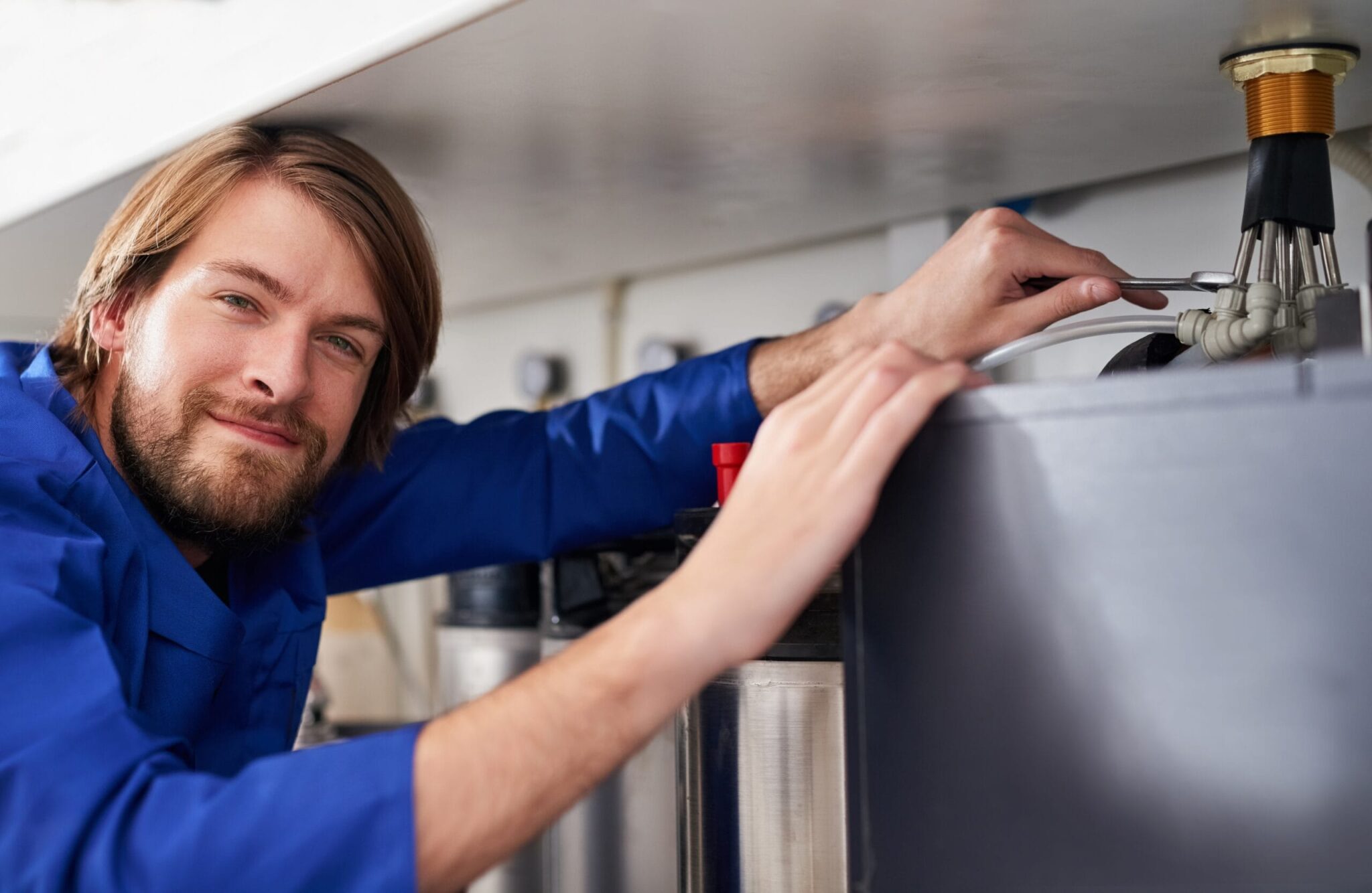 Technician servicing a residential water heater tank in Prescott